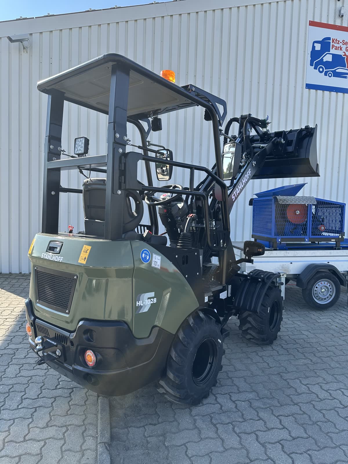 Hoflader HL1028 von hinten mit Schutzdach und Ladeschaufel