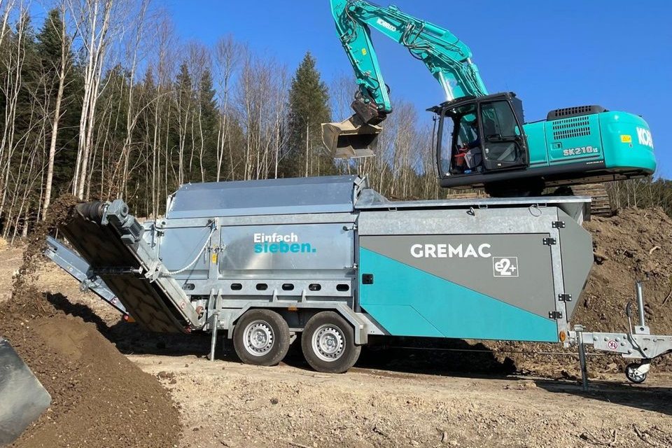 Gremac e2+ wird per Bagger mit Aushub befüllt